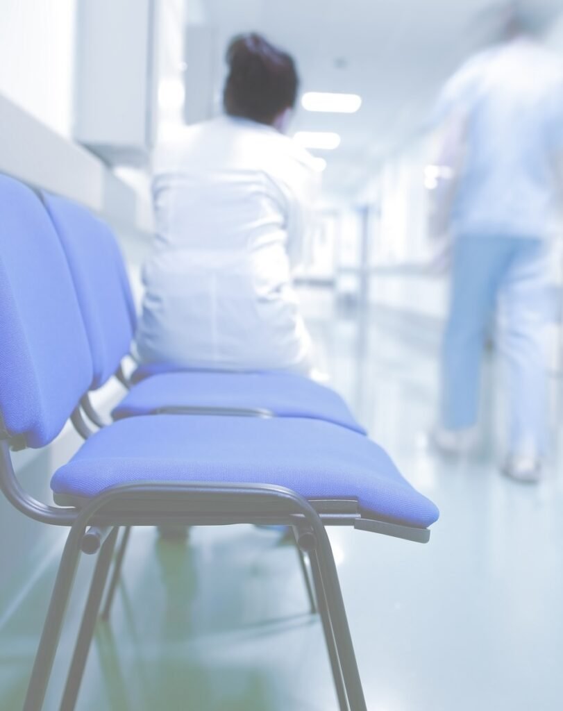 Medical workers in urgent care waiting area and hallway.
